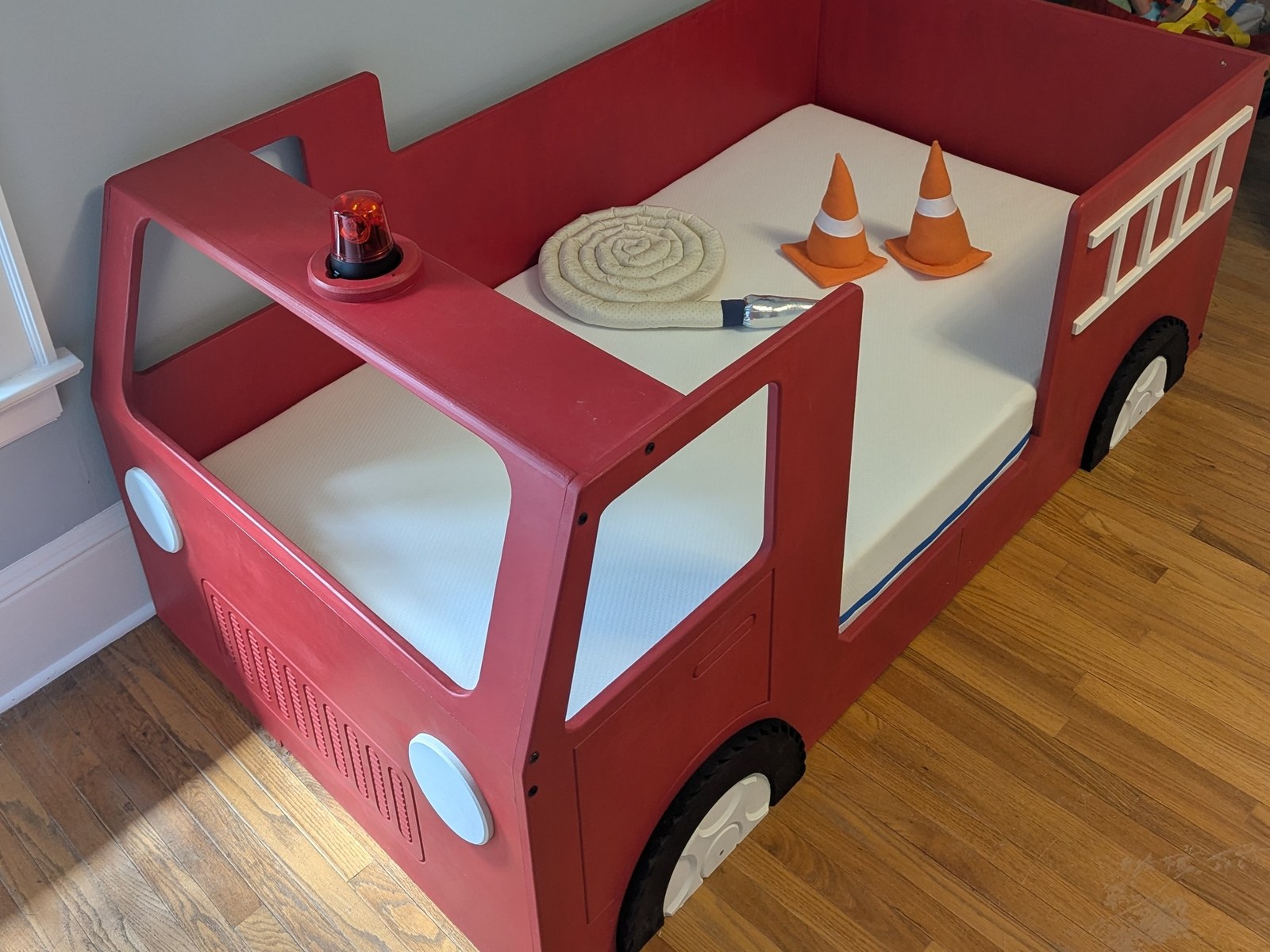 Fire truck toddler bed — Cab, ladder, and a beacon that turns